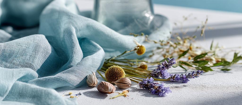 Licht en luchtig stilleven met blauwe stof en fijne kruiden, passend bij de Vata-energie