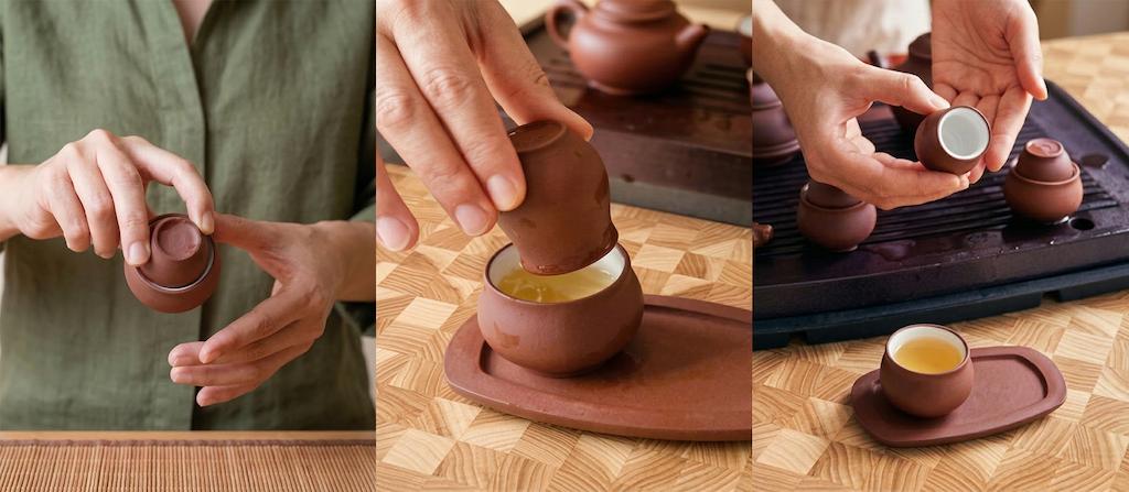 A tea drinker brings a small tasting cup with freshly brewed tea close to the nose and gently inhales to perceive the tea’s aromas before tasting it.